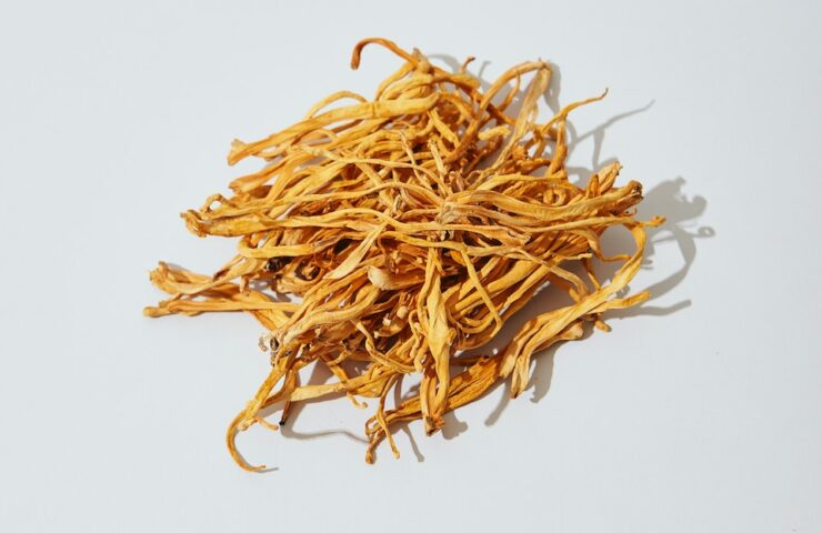 a pile of dried yellow flowers on a white surface