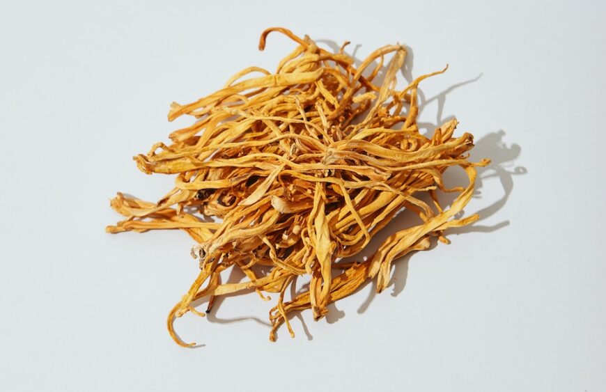 a pile of dried yellow flowers on a white surface